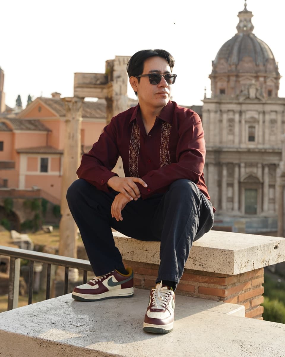 Alfredo Estevez sitting on a ledge overlooking the Roman Forum